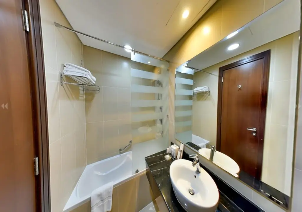 نمایی از حمام اتاق Executive Room با سینک و آینه بزرگ